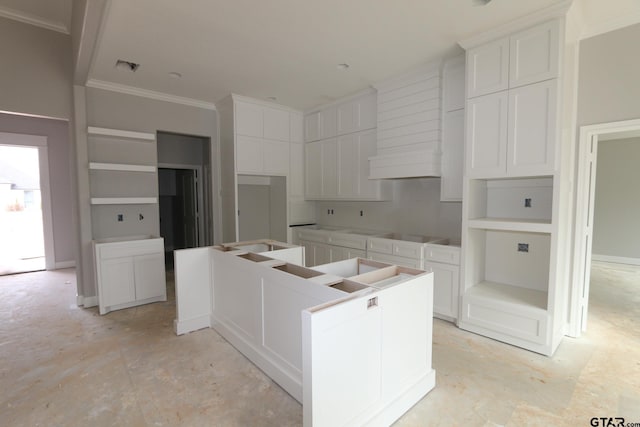 kitchen featuring a center island, white cabinetry, and crown molding