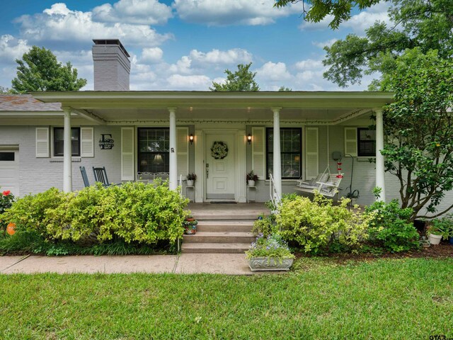 14900 Fm 848, Whitehouse, TX 75791 - view of front of house featuring a chimney, covered porch, a front yard, and brick siding