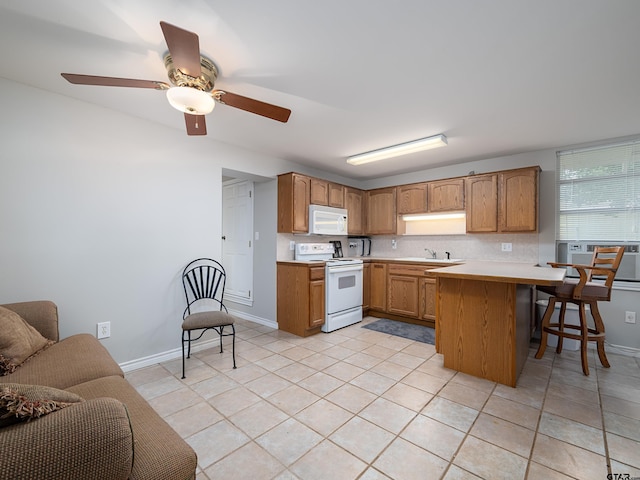 14900 Fm 848, Whitehouse, TX 75791 - kitchen with white appliances, a peninsula, a breakfast bar area, light countertops, and brown cabinetry