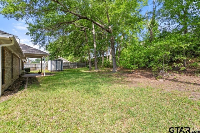 view of yard with a fenced backyard, an outbuilding, and a storage shed