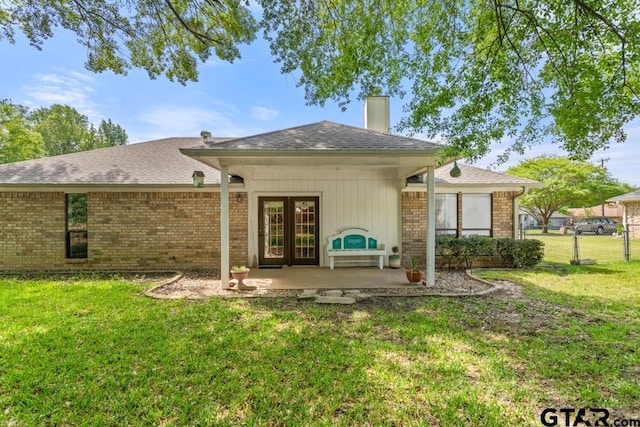 rear view of house featuring fence, french doors, a yard, and a patio