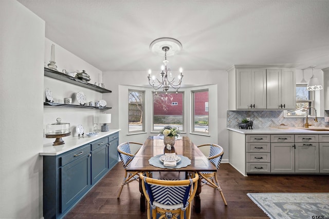 dining space with a wealth of natural light, a notable chandelier, dark wood-type flooring, and baseboards