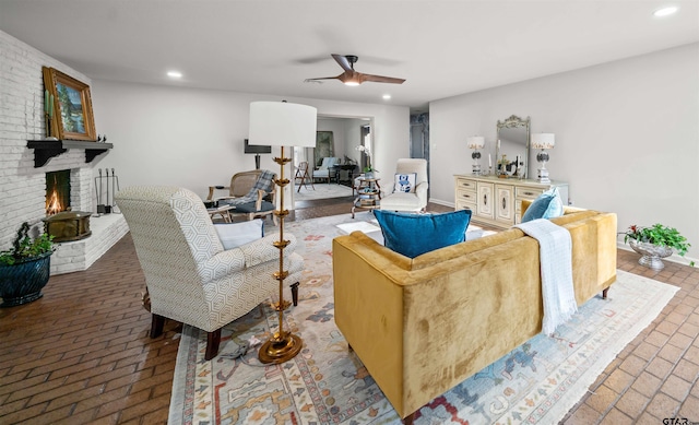 living area featuring recessed lighting, a brick fireplace, brick floor, and a ceiling fan