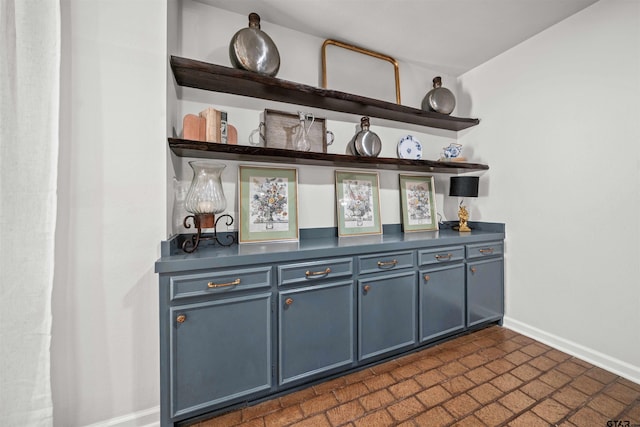 bar featuring brick floor and baseboards