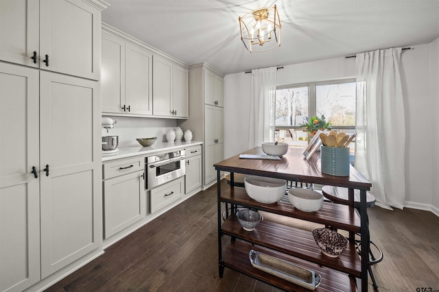 kitchen with white cabinets, light countertops, dark wood-type flooring, and stainless steel oven