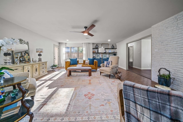 living area with baseboards and a ceiling fan