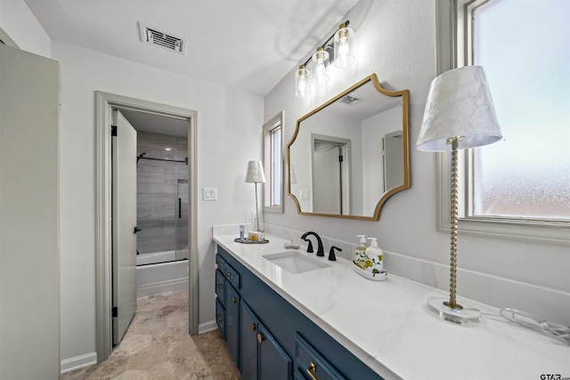 bathroom featuring visible vents, vanity, and bath / shower combo with glass door