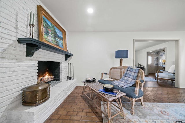 interior space with a fireplace, brick floor, and baseboards