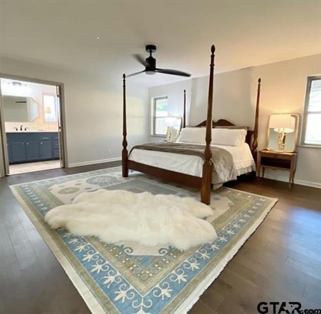 bedroom with wood finished floors, baseboards, and ensuite bathroom