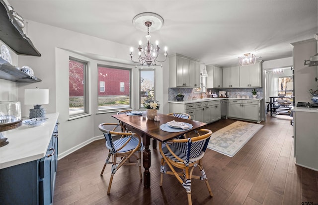 dining room with baseboards, a notable chandelier, a healthy amount of sunlight, and dark wood-style floors