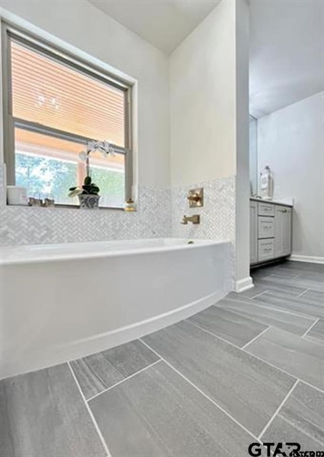 full bathroom with a bath and vanity