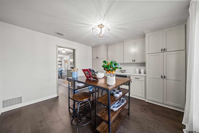 dining room featuring visible vents, baseboards, an inviting chandelier, and dark wood finished floors