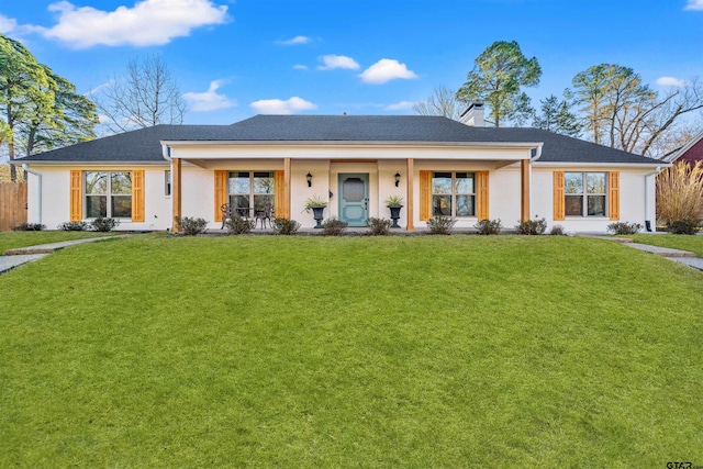 view of front of property with covered porch, a chimney, and a front lawn