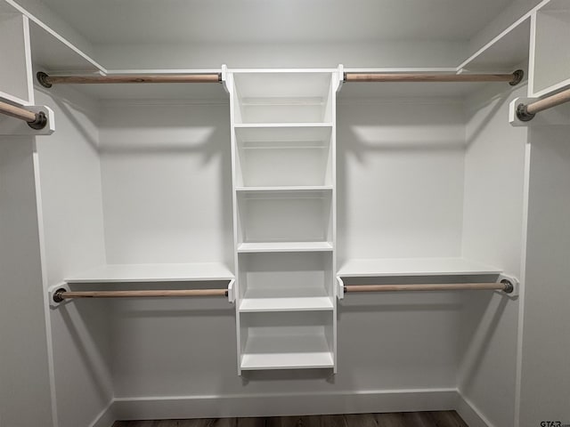 spacious closet with dark wood-type flooring