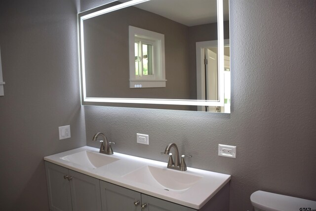 613 Northgate Rd, Hideaway, TX 75771 - bathroom featuring toilet, double vanity, a sink, and a textured wall