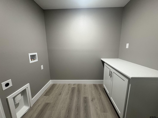 washroom with cabinet space, hookup for a washing machine, light wood-style flooring, baseboards, and hookup for an electric dryer