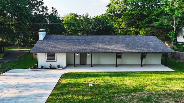 view of front of property with a shingled roof, fence, a chimney, and a front yard