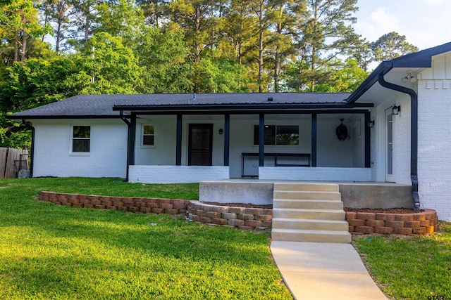 ranch-style house featuring brick siding, a front lawn, fence, and covered porch