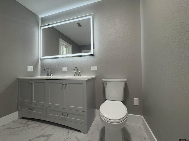 bathroom with visible vents, a sink, baseboards, toilet, and marble finish floor