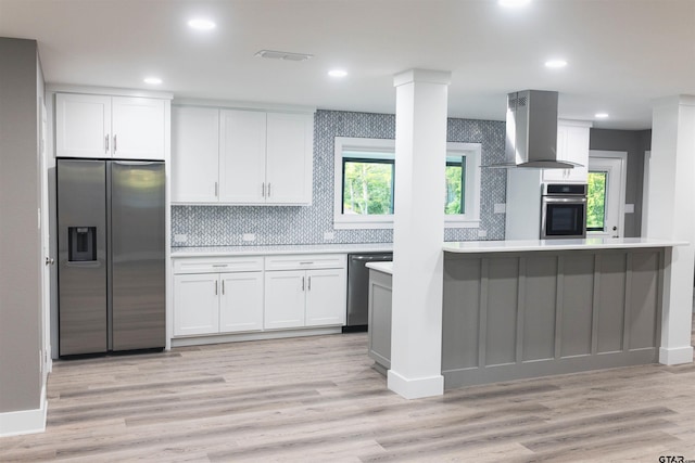 kitchen with island exhaust hood, visible vents, appliances with stainless steel finishes, light countertops, and white cabinetry