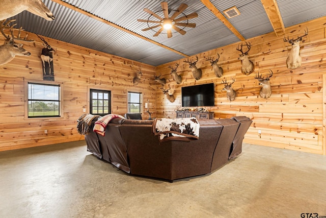 12093 County Road 152 W, Bullard, TX 75757 - living room with wood walls, ceiling fan, and finished concrete floors