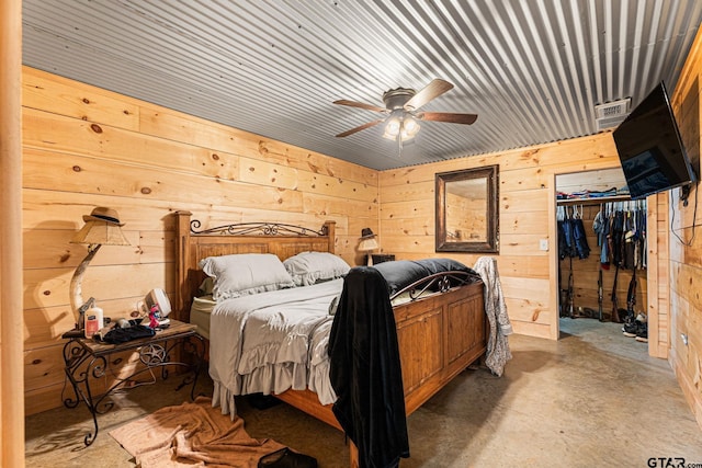 12093 County Road 152 W, Bullard, TX 75757 - bedroom with wood walls, concrete floors, a closet, a spacious closet, and a ceiling fan