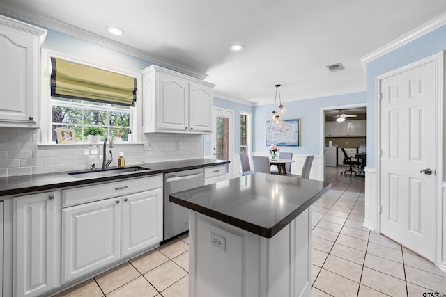 4918 Pine Knl, Tyler, TX 75703 - kitchen with stainless steel dishwasher, a sink, dark countertops, white cabinets, and ornamental molding