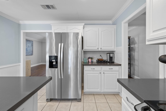4918 Pine Knl, Tyler, TX 75703 - kitchen featuring stainless steel fridge with ice dispenser, dark countertops, ornamental molding, white cabinetry, and light tile patterned floors