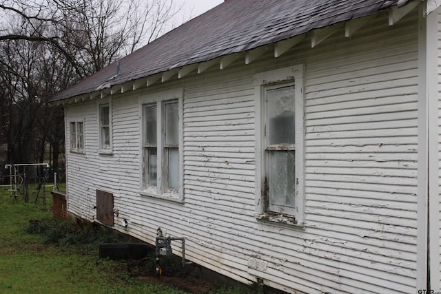 view of side of home featuring crawl space and a shingled roof