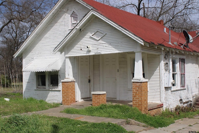 bungalow-style home featuring brick siding and covered porch