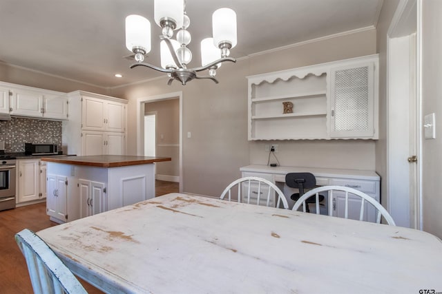 dining space featuring an inviting chandelier, ornamental molding, and dark wood finished floors