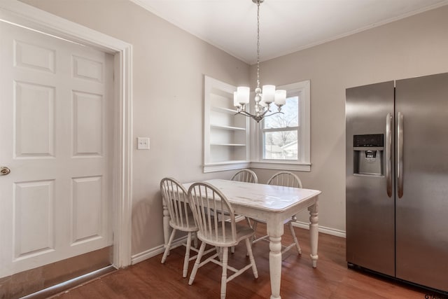 dining room with a notable chandelier, baseboards, and wood finished floors