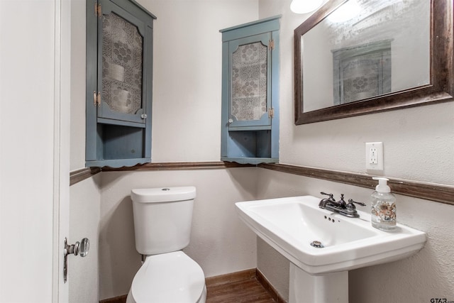 bathroom with a sink, toilet, and wood finished floors