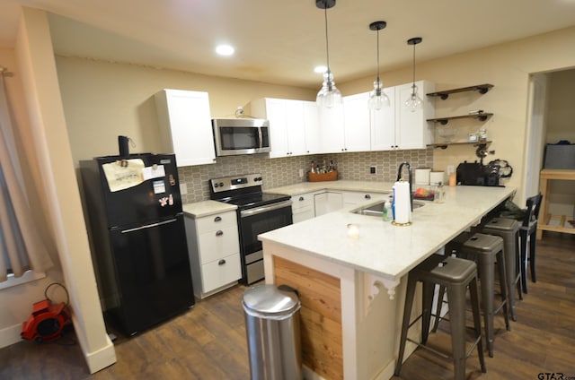 kitchen featuring appliances with stainless steel finishes, dark hardwood / wood-style flooring, a breakfast bar, sink, and white cabinets