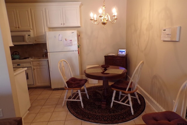 dining area with light tile patterned flooring and a chandelier