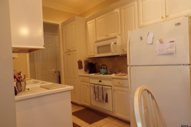 kitchen featuring white appliances, white cabinets, backsplash, and light tile patterned floors