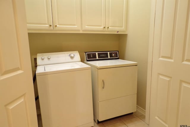 laundry area with light tile patterned floors, cabinets, and independent washer and dryer