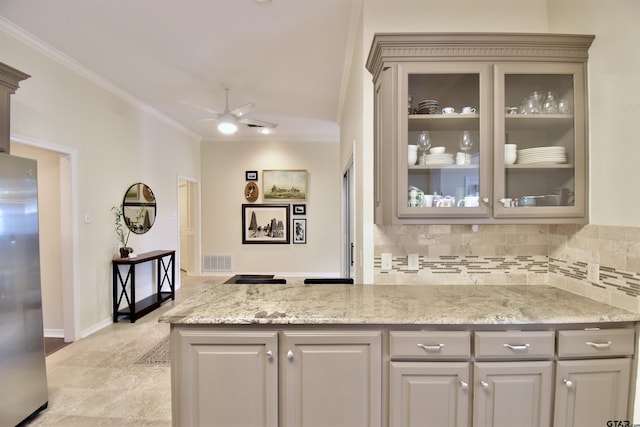 1406 Kingspark Dr, Tyler, TX 75703 - kitchen featuring freestanding refrigerator, decorative backsplash, ornamental molding, glass insert cabinets, and ceiling fan