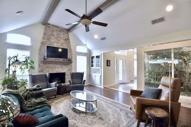 1406 Kingspark Dr, Tyler, TX 75703 - living room with a ceiling fan, wood finished floors, plenty of natural light, beamed ceiling, and a brick fireplace