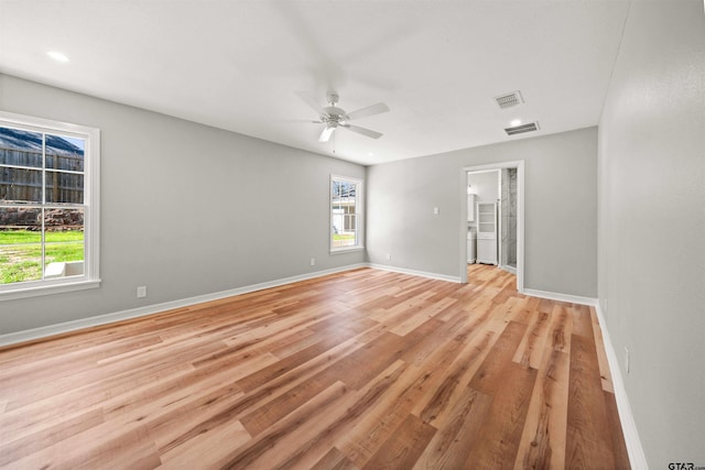 spare room featuring a wealth of natural light, ceiling fan, and light wood-type flooring