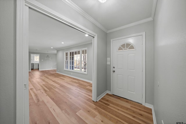 entryway featuring light wood-type flooring, crown molding, and a chandelier