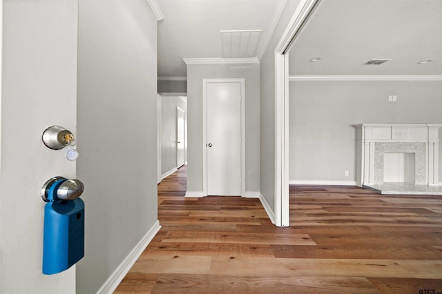 corridor featuring wood-type flooring and ornamental molding