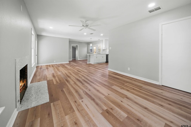 unfurnished living room featuring ceiling fan and light hardwood / wood-style floors