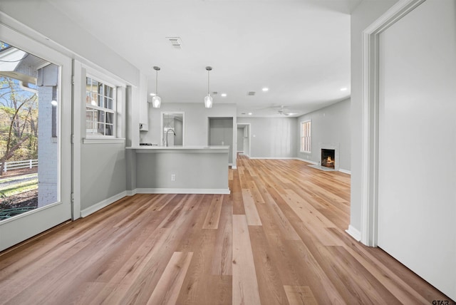 unfurnished living room featuring light hardwood / wood-style flooring and ceiling fan