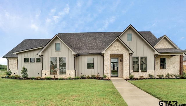 modern inspired farmhouse with a front lawn and board and batten siding