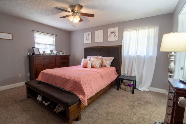 carpeted bedroom featuring a textured ceiling and ceiling fan