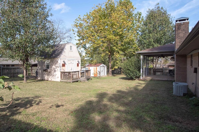 view of yard featuring a storage shed, central air condition unit, and a wooden deck