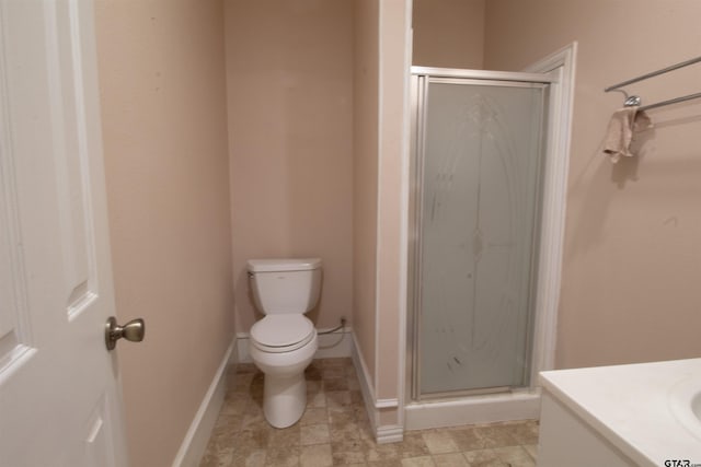 bathroom with a shower with door, vanity, and toilet