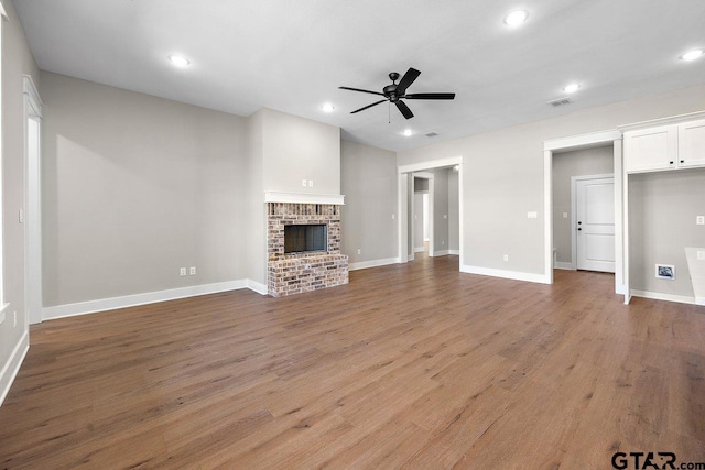 unfurnished living room with ceiling fan, hardwood / wood-style floors, and a fireplace