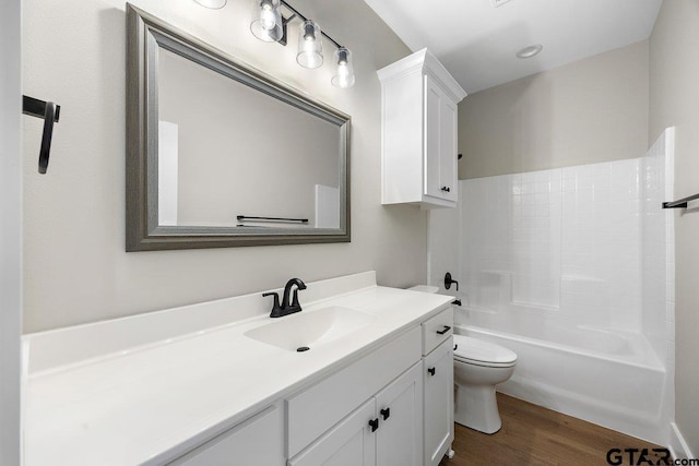 full bathroom featuring toilet, vanity, hardwood / wood-style floors, and bathtub / shower combination